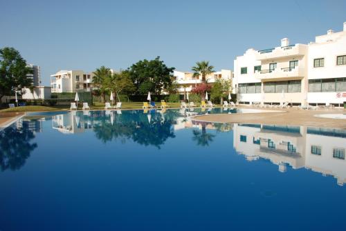 a pool of water in front of a building at Terraço e Mar in Alvor