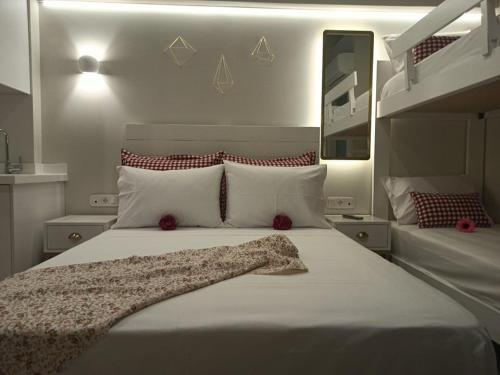 um quarto com uma grande cama branca com almofadas vermelhas em Anastasia Mare Luxury em Stavros