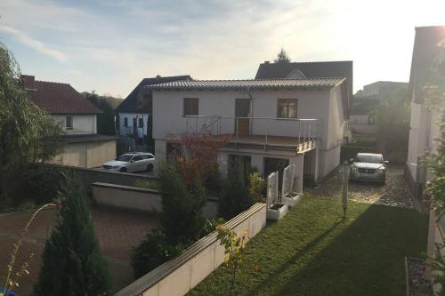 ein weißes Haus mit Autos auf einem Hof in der Unterkunft Ferienwohnung Franz Jäger Berlin in Gützkow
