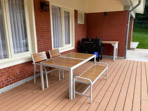 a table and chairs on a deck with a grill at American Village Resort in Taipei