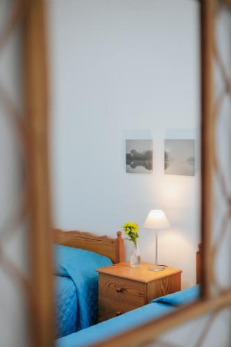 a bedroom with a bed and a table with a lamp at Lazaros Centre Apartment in Larnaka