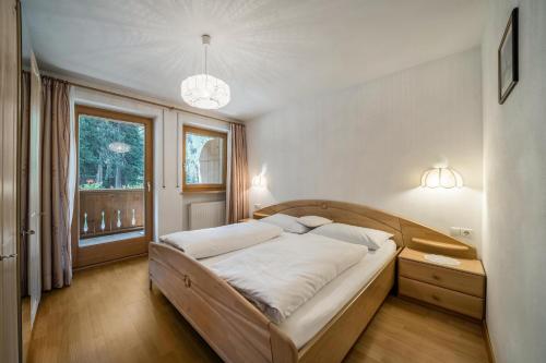 Un dormitorio con una cama grande y una ventana en Ferienhaus Maria Schneeglöcklein en Pfelders