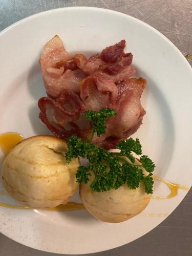 un piatto bianco di cibo con patate e pancetta di Gowrie Farm Golf Lodge a Nottingham Road