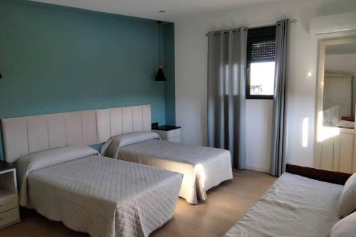 a hotel room with two beds and a window at Alojamiento Rural La Viña del Cerezo in Huelma