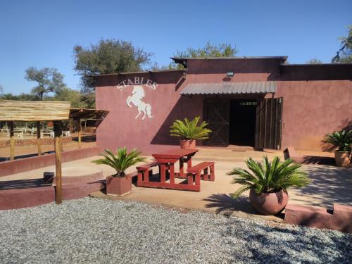 a building with a table and benches in front of it at ThabaNkwe Bushveld Inn in Thabazimbi