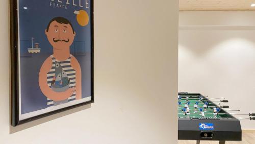 a poster of a man with a mustache on a wall next to a giant game at Chalet Azalée, Montriond, Morzine, Avoriaz in Montriond