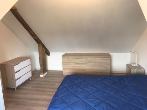 - une chambre mansardée avec un lit et une commode dans l'établissement Hébergements situés à 6 kms du Mont Saint Michel, à Tanis