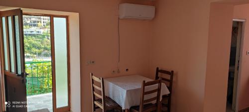 um pequeno quarto com uma mesa, cadeiras e uma janela em Amalias room em Himare