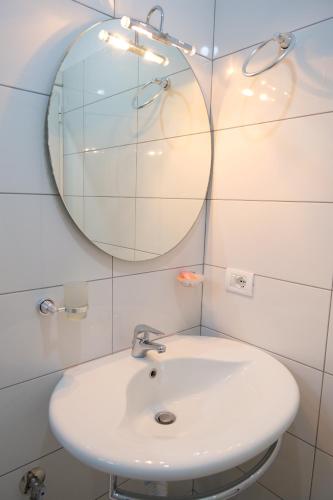 a bathroom with a white sink and a mirror at Villa Allkushi in Sarandë