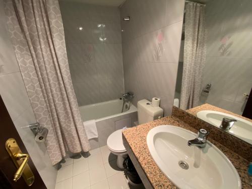 a bathroom with a sink, toilet and bathtub at Somriu Hotel City M28 in Andorra la Vella