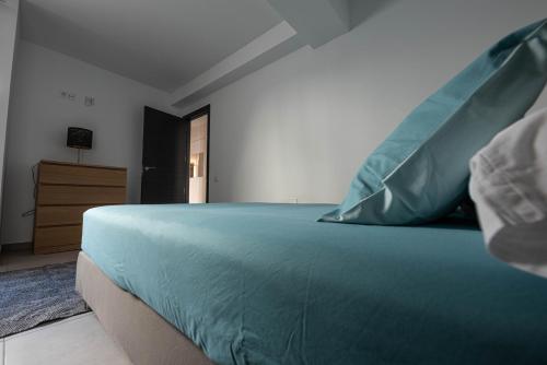 Un dormitorio con una cama con almohadas azules. en Edificio Prieto VIV 2 en Puerto del Rosario