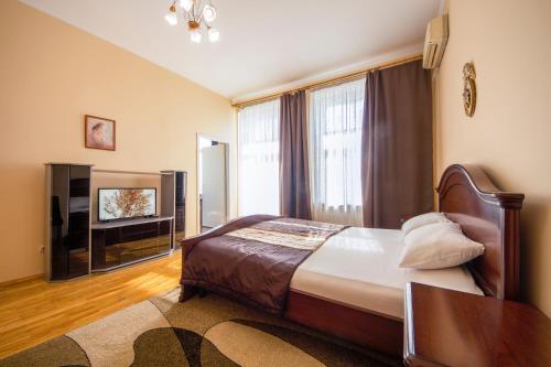 ein Schlafzimmer mit einem Bett und einem TV in der Unterkunft DayFlat Apartments Olimpiyska Area in Kiew