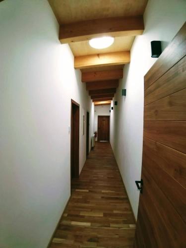 a hallway with wooden floors and white walls and wooden ceilings at Kafé Ořech in Mnichovo Hradiště