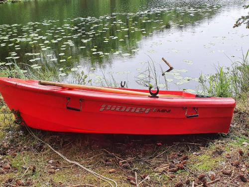 a red boat sitting on the side of a lake at 6 person holiday home in Fonnes-By Traum in Fonnes