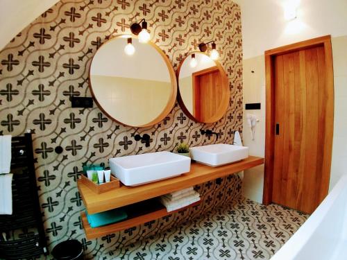 a bathroom with two sinks and two mirrors at Kafé Ořech in Mnichovo Hradiště
