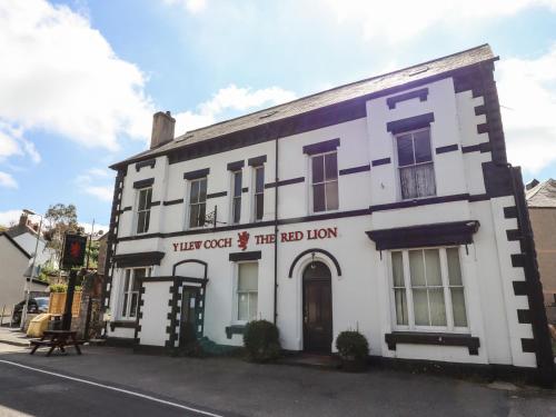 a white building on the corner of a street at Strength Rooms in Rhyl