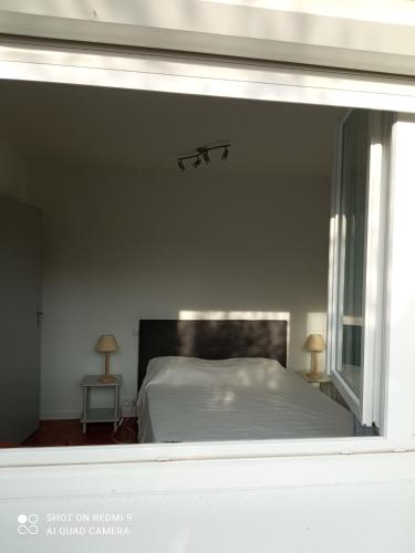 a bedroom with a white bed and a window at A Berdot in Dax