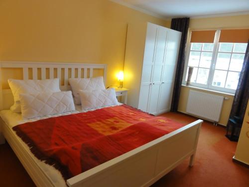 una camera da letto con un grande letto con una coperta rossa di Villa Isabell a Binz