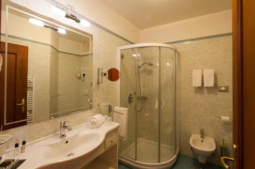 a bathroom with a shower and a sink and a toilet at Sartori's Hotel in Trento