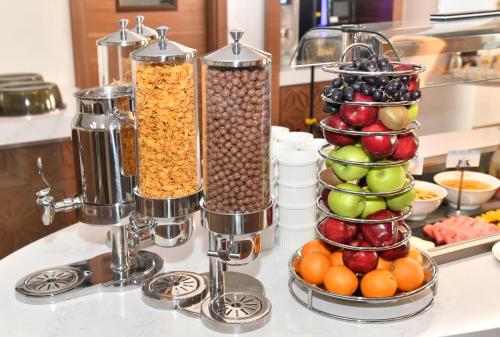 a kitchen counter with two tall containers of fruit at Golden Tulip Riyadh Convention and Exhibition Center in Riyadh