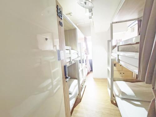 a room with several bunk beds in a hospital at Paper Plane Hostel in Kaohsiung