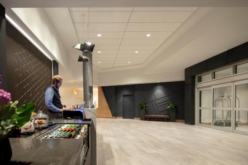 a man standing at a counter in a lobby at Hyatt Place Moncton-Downtown in Moncton