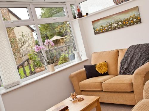 a living room with a couch and two windows at Littlebeck Warren in Whitehaven