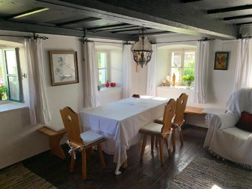 a dining room with a white table and chairs at Ferienhaus Rötzer Maria in Grafenau