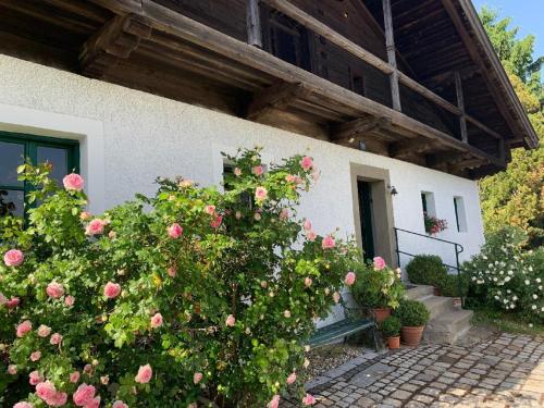 a house with pink roses in front of a building at Ferienhaus Rötzer Maria in Grafenau