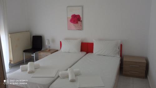 a bedroom with two beds with white sheets and a desk at Elea House in Keramoti