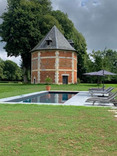 - un bâtiment en briques avec une piscine sur gazon dans l'établissement Chateau de St MACLOU, à Saint-Maclou