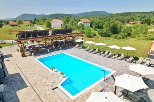 uma imagem de uma piscina num resort com guarda-sóis em 16 Lakes Guesthouse em Grabovac