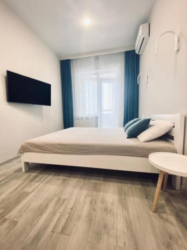 a bedroom with a bed and a tv on a wall at АПАРТАМЕНТЫ ВОЗЛЕ МОРЯ (КРАСИВЫЙ ЗАКАТ). in Odesa