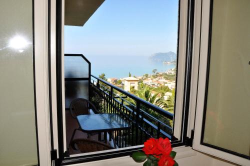 a balcony with a table and a view of the ocean at Dina's Paradise in Agios Gordios