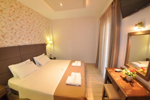 a hotel room with a bed and a mirror at Dina's Paradise in Agios Gordios