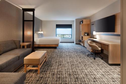 a hotel room with a couch and a bed and a desk at Hyatt Place Moncton-Downtown in Moncton