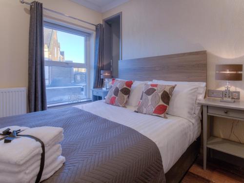 a bedroom with a large bed with a window at Remaotel The Bromley Apartments in Great Yarmouth