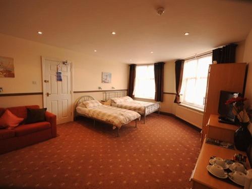 a living room with a bed and a couch at Hussar Inn in Margate