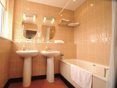 馬蓋特的住宿－輕騎兵旅館，浴室配有盥洗盆和浴缸。