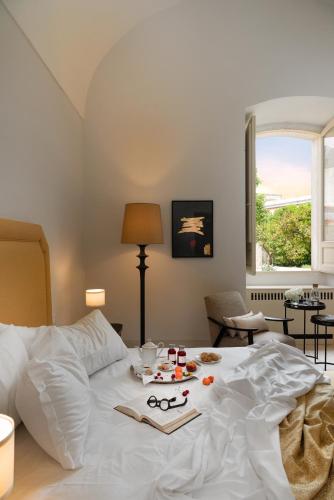 a white bed with a tray of food on it at Palazzo Donna Elisabetta in Manduria