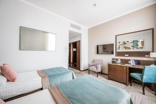 a hotel room with two beds and a desk at Europeum Hotel in Wrocław