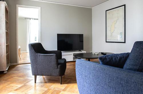 - un salon avec une télévision, 2 chaises et une table dans l'établissement Karl-Oskars Krypin, à Visby