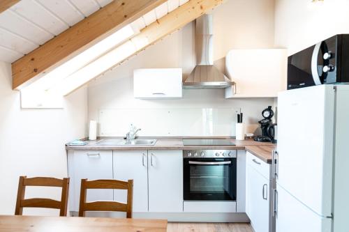 a kitchen with white cabinets and a white refrigerator at Ferienwohnung Bad Camberg - Apartment Weisse Graeben in Bad Camberg