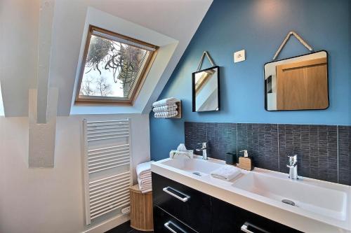 W łazience znajduje się umywalka i lustro. w obiekcie KER LONGITUDE w mieście Dinan