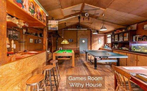 a room with a ping pong table and a bar at Withy Cottages in Langport