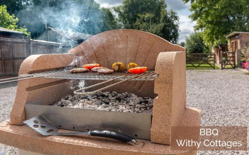 a bbq grill with meat and vegetables on it at Withy Cottages in Langport