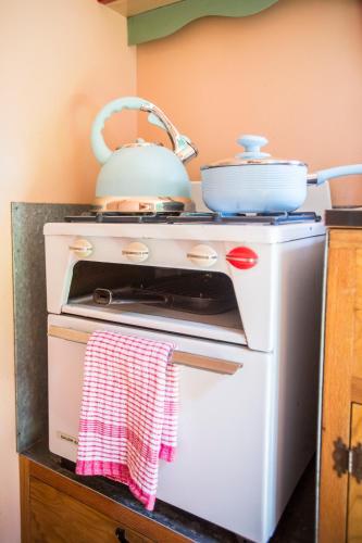 a white stove with a tea kettle on top of it at Withy Cottages in Langport