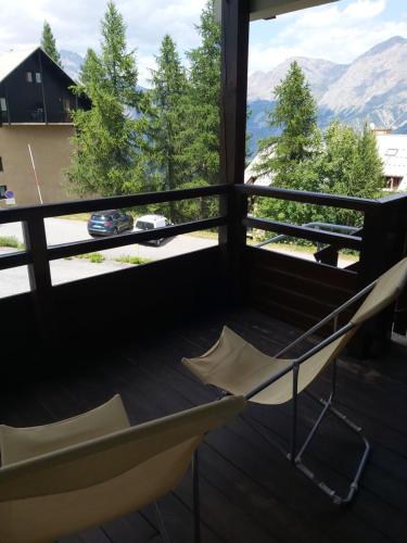 balcón con silla y vistas a las montañas en Chalet gentiane 1700 en Puy-Saint-Vincent