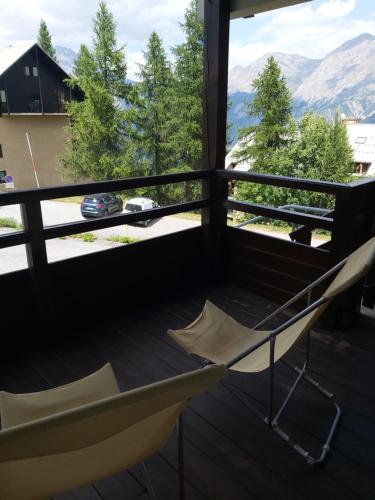 a balcony with a chair and a view of mountains at Chalet gentiane 1700 in Puy-Saint-Vincent