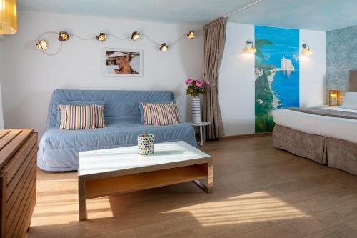 a living room with a blue couch and a bed at R&eacute;sidences Cresci in Cannes